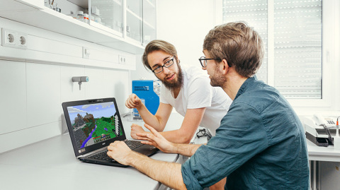 Die Psychologiestudenten Thomas Birnbaum (li.) und Valentin Baumann (re.) besprechen eine virtuelle Umgebung, die Kinder und Jugendliche erkunden sollen. Beide haben gerade ihre Masterarbeit abgeschlossen zum Thema „Behavioral Tagging“, dem besseren Speichern von Lehrinhalten durch zeitlich nahe Präsentation von neuen Eindrücken