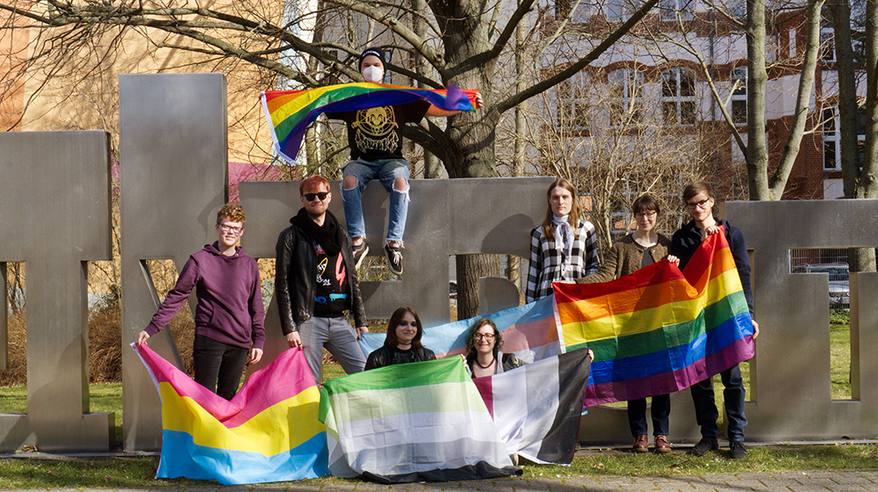 The team of the student initiative OVGUpride in front of the uniporta with rainbow flags (c) private