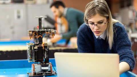 junge Frau programmiert einen Roboter (Foto: Shutterstock / NDAB Creativity)