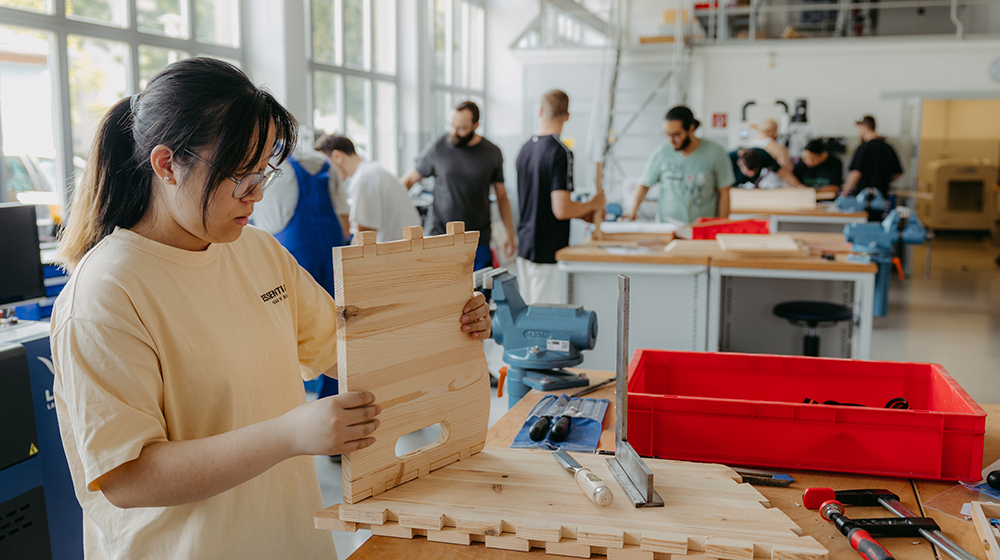 Studentin bearbeitet ein Stück Holz in der StudierendenWerkstatt (c) Jana Dünnhaupt Uni Magdeburg