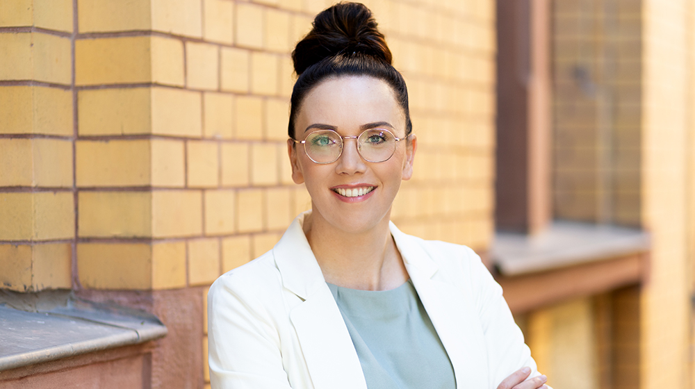 Portrait of Dr. Anne Gieseler in front of a yellow brick building (Photo: Sarah Kossmann UMMD)