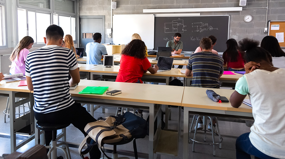 /unimagdeburg_media/Presse/Bilder/Pressemitteilungen/2026/Ein+Blick+auf+Sch%C3%BClerinnen+und+Sch%C3%BCler+von+hinten+in+einer+Klasse_+ein+Lehrer+sitzt+vor+der+Tafel+%28c%29+shutterstock-height-560-width-1000-p-146212.jpg